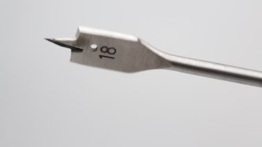 Manuel çalışma kavramı gibi beyaz arka planda bir matkap biti sayısının on sekiz dönüşü