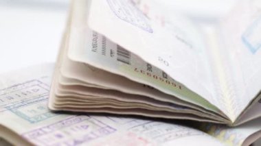 Beyaz arka planda çok sayıda seyahat pulu olan yakın çekim pasaportları