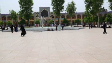 İran'da minarenin eski meydanında yürüyen insanlar