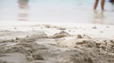 okyanusa yakın sahilde yürüyen insanların ayakları