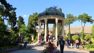 İran 'da Pers şairin mezarının yakınında yürüyen turistler