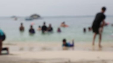 yaz aylarında sahilde dinlenen insanların bulanık görünümü