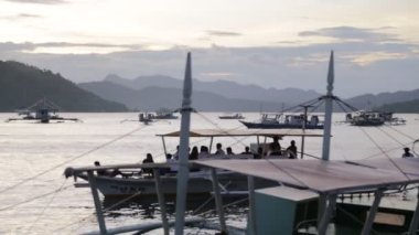 Filipinler 'de gün batımı denizde bir tekne insanlar ve turistler