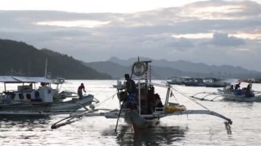 Filipinler 'de gün batımı denizde bir tekne insanlar ve turistler