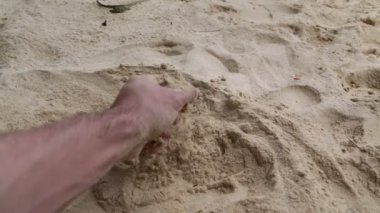 sahilde kuma dokunan adamın kırpılmış çekimi
