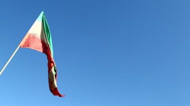 İran bayrağı mavi gökyüzüne karşı rüzgar hareket