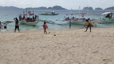 Filipinler 'de deniz tekneleri gelen insanlar ve turistler kum plaj