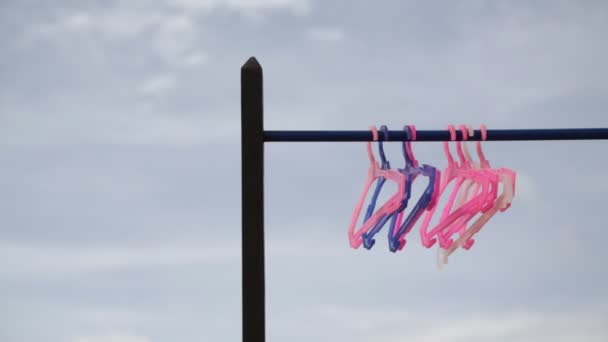 曇り空に立つピンクと紫のハンガー — ストック動画