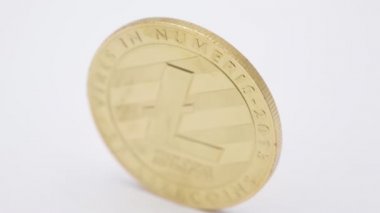 litecoin simgesi olan altın madeni para üzerinde beyaz masa üstü hareketli yakın çekim görüntüleri