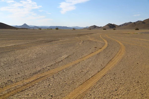 砂漠の岩山と野生の概念のようなトラックと自然風光明媚な土地の真ん中に — ストック写真