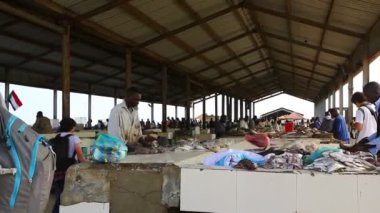 Kimliği belirsiz kişiler pazarda balık satıyor