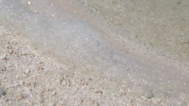 Deniz köpük, su ve sandy plaj yakın çekim