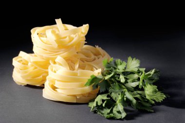 Maydanoz siyah bir arka plan ile makarna fettuccine.
