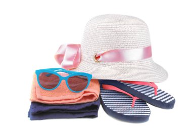 Bir mavi ve beyaz şerit bir turuncu ve mavi havlu ve mavi gözlük yanında yaz şapka ile flip floplar. İzole