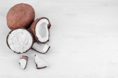 Hindistan cevizi Hindistan cevizi talaşı ve küçük parçalar halinde beyaz ahşap zemin üzerine Hindistan cevizi ile yarısı. Üstten görünüm