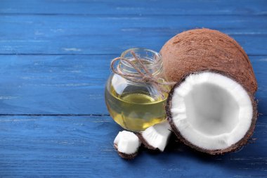 Hindistan cevizi ve Hindistan cevizi yağı mavi ahşap zemin ile yarım Hindistan cevizi