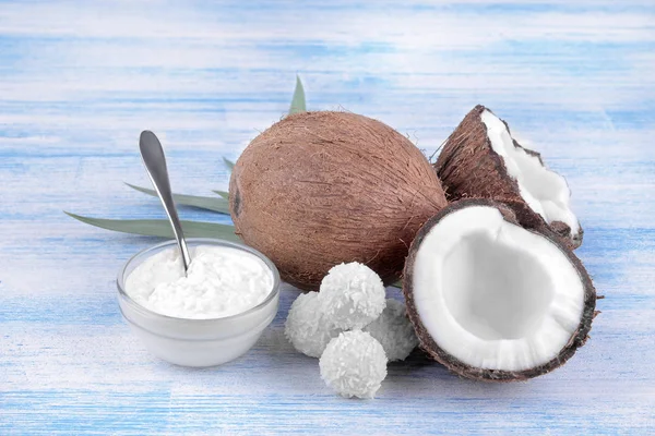 Coconut with coconut sweets and fresh coconut oil on a blue wooden background