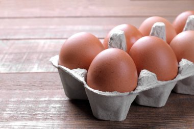 Kahverengi tavuk yumurta yumurta kahverengi ahşap arka plan üzerinde bir tepsi içinde.