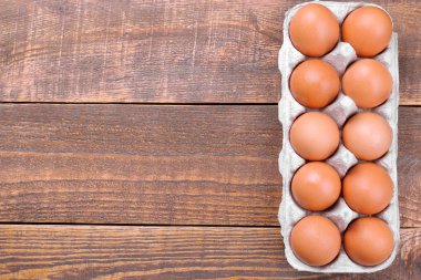 Kahverengi tavuk yumurta yumurta kahverengi ahşap arka plan üzerinde bir tepsi içinde. Üstten görünüm