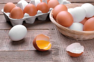 Tavuk yumurta sarısı yakın çekim sepeti ve tepsi içinde yumurta yanındaki ile kahverengi ahşap arka plan üzerine doğranmış