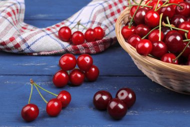 çok taze, olgun kiraz mavi ahşap arka plan üzerinde bir sepet içinde