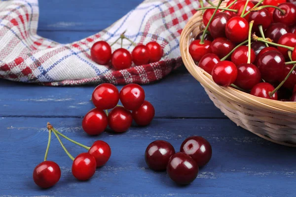 çok taze, olgun kiraz mavi ahşap arka plan üzerinde bir sepet içinde