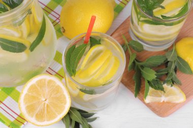Ev yapımı limonata limon ve nane bir cam sürahi ve bardak taze limon Beyaz ahşap zemin üzerinde yanında