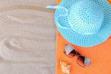 Yaz aksesuarları. Şapka ve güneş gözlüğü ve denizde bir havlu. Üstten görünüm