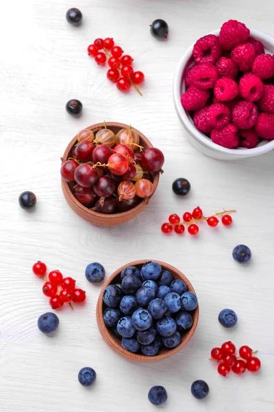 Yakın çekim dahil böğürtlen, ahududu, böğürtlen kuş üzümü ve Bektaşi Beyaz ahşap zemin üzerinde çeşitli taze çilek.