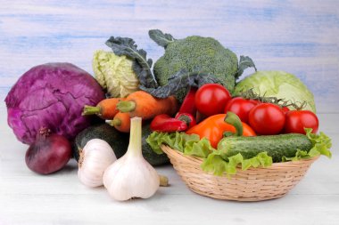 Pancar, lahana, kabak, havuç, domates, biber, soğan, sarımsak ve salatalık ve marul beyaz ve mavi ahşap arka plan üzerinde birçok farklı sebze dahil.