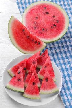 Parlak olgun dilimleri ile büyük ve sulu karpuz Beyaz ahşap zemin üzerinde beyaz tabakta karpuz