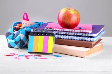 Bir kalem durumda, kitap ve egzersiz kitap beyaz ahşap zemin üzerinde de dahil olmak üzere çeşitli okul malzemeleri