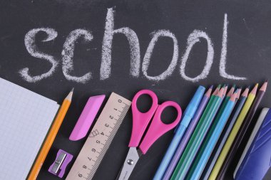 Kitap, kalem durumda, bir cam ve okul yönetimi ile bir yazıt arka plan üzerinde bir defter kalem çeşitli okul malzemeleri.