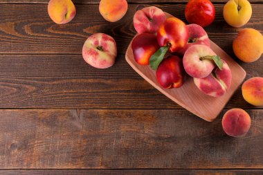 bir kompozisyon şeftali kesme tahtası bir yazıt için bir yer bir kahverengi ahşap zemin üzerine birçok çeşitleri. Üstten görünüm