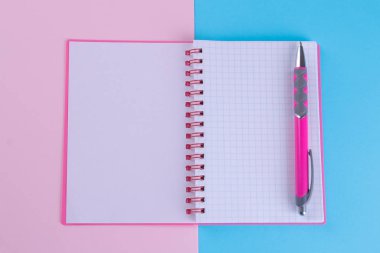Pembe notebook parlak çok renkli arka plan üzerinde pembe bir kolu ile gelişeceğini formunda. Okul malzemeleri
