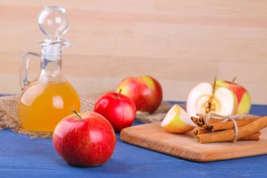 Mavi ahşap arka plan üzerinde taze olgun elma ile elma sirkesi