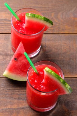 Karpuz smoothies ve kahverengi ahşap bir masa üzerinde taze karpuz dilimleri ile kompozisyon