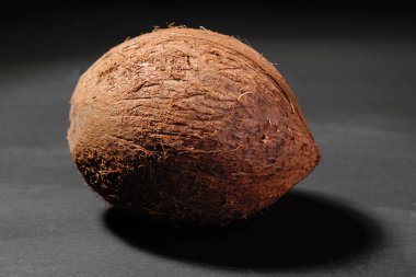 Büyük tüm Hindistan cevizi yakın çekim siyah bir tablo ve siyah bir arka plan