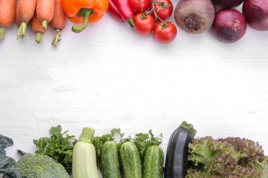 taze sebze domates biber lahana pancar kabak ve havuç yaprakları salata ve salatalık mercimek Beyaz ahşap bir masa üzerinde de dahil olmak üzere çeşitli. yukarıdan görüntüleyin. yazıt ile yer