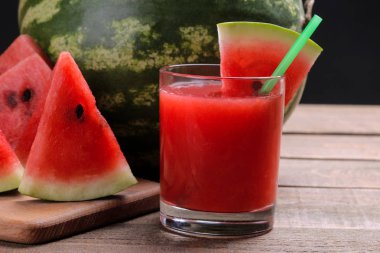 Karpuz smoothies kahverengi ahşap bir masa ve arka planda büyük bir karpuz karpuz dilimleri ile