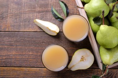 Armut suyu bir bardak kahverengi ahşap bir masa üzerinde taze olgun armut ile. üstten görünüm