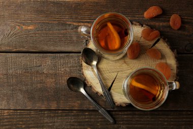 Sıcak çay ve kuru kayısı ile yazıt için bir yer kahverengi ahşap bir masa üzerinde sonbahar kompozisyonu. üstten görünüm