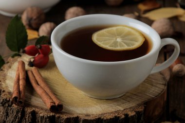 Bir ahşap stand, tarçın, köpek rose, kahverengi ahşap bir masa fındık sıcak çay ile sonbahar kompozisyon