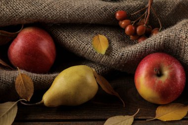 Meyve elma ve armut ve kahverengi ahşap bir masa üzerinde sarı sonbahar yaprakları ile sonbahar düzenleme