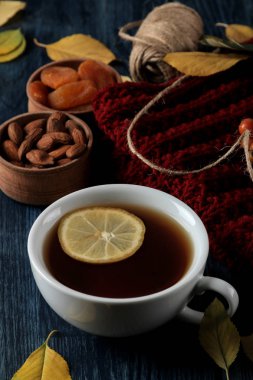 Sıcak çay fındık ile sonbahar kompozisyon çilek ve koyu mavi ahşap bir masa üzerinde sarı sonbahar yaprakları