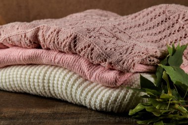 Bir kahverengi ahşap arka plan üzerinde Kazıklı çeşitli sıcak kazak ile sonbahar kompozisyon