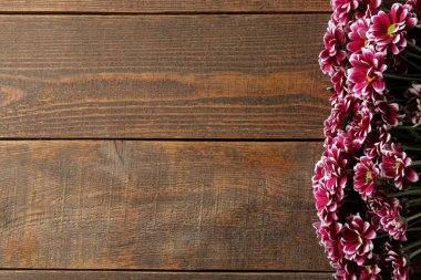 Sonbahar çiçeklerin kasımpatı bir yazıt için bir yer ile kahverengi ahşap bir masa üzerinde çerçeve. üstten görünüm