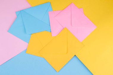 Parlak renkli arka plan üzerinde renkli posta zarflar. yukarıdan görüntüleyin. posta veya teslim kavramı