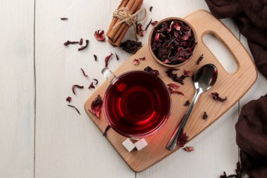 Cam bardak çay sıcak kırmızı pembe beyaz ahşap bir masa üzerinde kuru çay ile. Üstten görünüm.