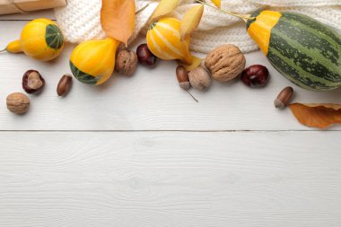 Dekoratif kabaklar ve sarı yaprakları ve sıcak bir eşarp sonbahar kompozisyonu. Sonbahar zaman. Beyaz ahşap bir masa üzerinde. yazıt yeri olan üstten görünüm